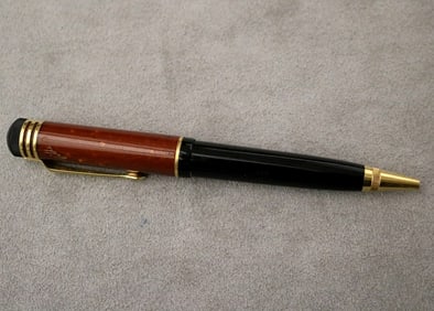 MONTBLANC BALLPOINT PEN WITH RUST-RED AND BLACK BARREL.