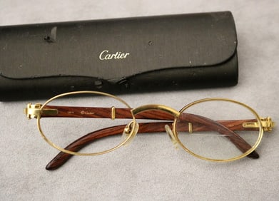 PAIR OF CARTIER YELLOW GOLD-PLATED EXOTIC WOOD EYE GLASSES WITH OVAL LENSES.