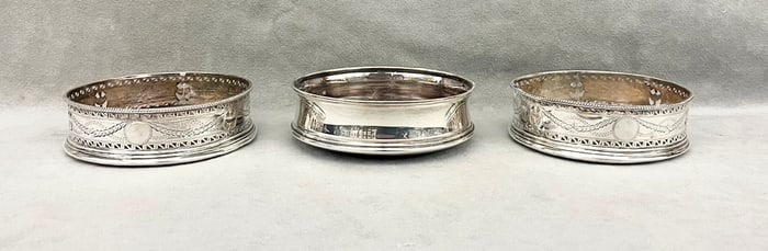 THREE ENGLISH SILVER WINE COASTERS.