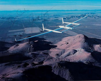 PHOTOGRAPH OF THE VOYAGER AIRCRAFT OVER THE MOJAVE DESERT SIGNED BY CREW DICK RUTAN AND JEANA