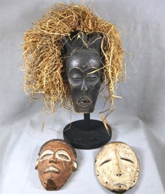 THREE PATINATED AFRICAN MASKS, Mid-20th century.