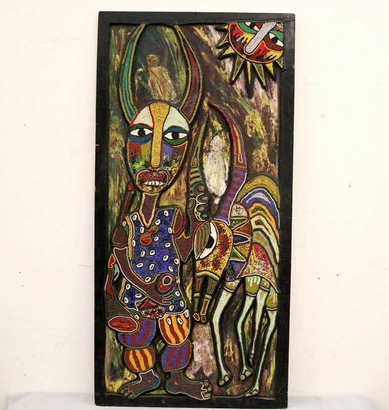 AFRICAN STYLE BEAD AND WOOD ART. African style relief art with hunter figure in mask, antelope, and: AFRICAN STYLE BEAD AND WOOD ART. African style relief art with hunter figure in mask, antelope, and figural sun in colored beads on raised plywood over a painted plywood background. Illegible signatur