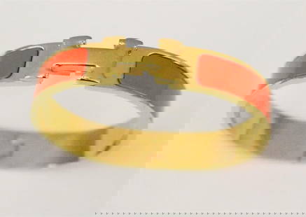 SIGNED HERMES/MADE IN FRANCE YELLOW-GOLD PLATED AND ORANGE ENAMEL HINGED OVAL "H" LOGO BRACELET,: SIGNED HERMES/MADE IN FRANCE YELLOW-GOLD PLATED AND ORANGE ENAMEL HINGED OVAL "H" LOGO BRACELET.  ;