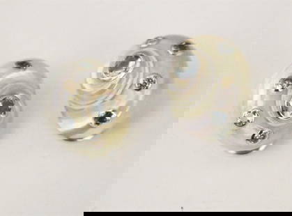 PAIR SIGNED TRIANON 18K WHITE GOLD AND COLORED GEMSTONE IRIDESCENT WHITE NAUTILUS-SHELL DESIGN: PAIR SIGNED TRIANON 18K WHITE GOLD AND COLORED GEMSTONE IRIDESCENT WHITE NAUTILUS-SHELL DESIGN CLIP-BACK EARRINGS.  Three blue and two amber color faceted round bezel-set gemstones - L: 3/4 in.