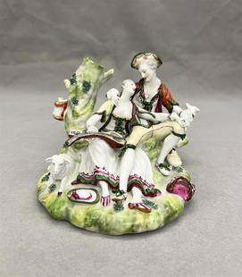 CONTINENTAL POLYCHROMED PORCELAIN FIGURE GROUP MODELED AS 18TH CENTURY COUPLE COURTING IN LANDSCAPE: CONTINENTAL POLYCHROMED PORCELAIN FIGURE GROUP MODELED AS 18TH CENTURY COUPLE COURTING IN LANDSCAPE WITH LUTE, LAMB AND DOG. 19th century. - H: 4 1/2 in.