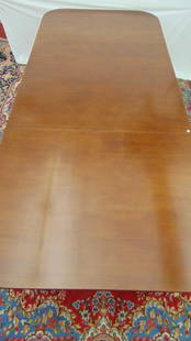 GEORGE III STYLE MAHOGANY TRIPLE-PEDESTAL BASE DINING TABLE WITH CENTER LEAF, - H: 29 in. L: 123 in.: GEORGE III STYLE MAHOGANY TRIPLE-PEDESTAL BASE DINING TABLE WITH CENTER LEAF.  Rectangular top with rounded corners and molded edge; three turned pedestals each carved with leafy overscrolls above fou