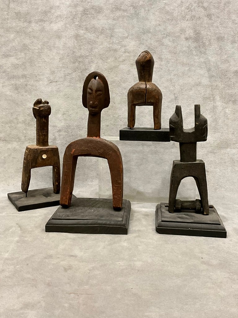 MALIAN CARVED HEDDLE PULLEYS, - Average height:.: MALIAN CARVED HEDDLE PULLEYS. Selection of four patinated and stylized hedley pulleys from either Bambara (Mali), Senufo (Ivory Coast) and/or Dan (Ivory Coast). - Average height:.