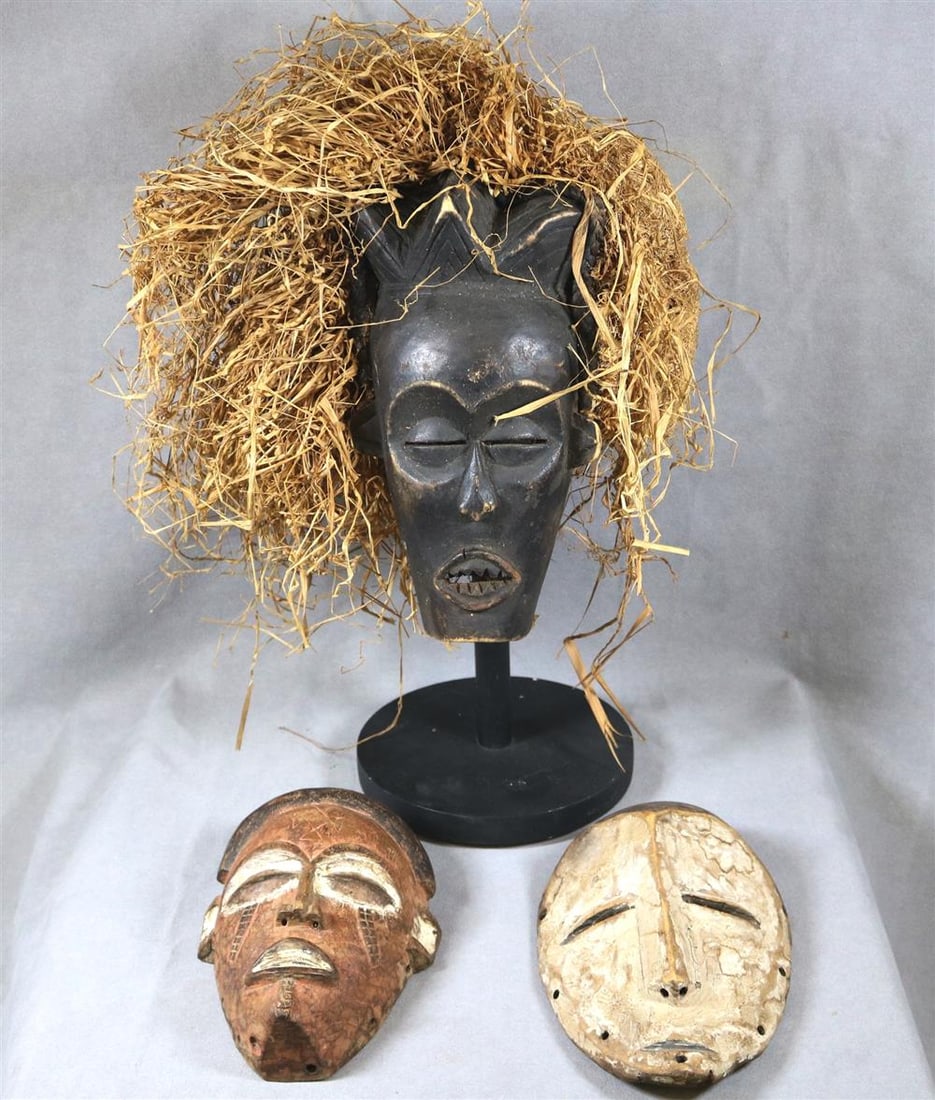 THREE PATINATED AFRICAN MASKS, Mid-20th century. (1 of 19)