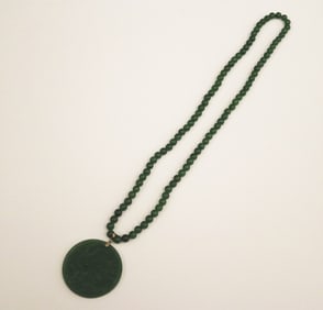 CHINESE CARVED DARK GREEN JADE MEDALLION SUSPENDED ON MATCHED JADE BEAD NECKLACE,