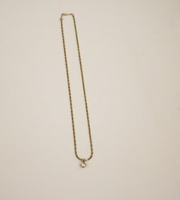 BRILLIANT-CUT ROUND DIAMOND SOLITAIRE PENDANT SUSPENDED ON YELLOW GOLD-PLATED CHOKER CHAIN.