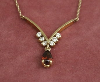 14K YELLOW GOLD, GARNET AND DIAMOND PENDANT CHOKER.