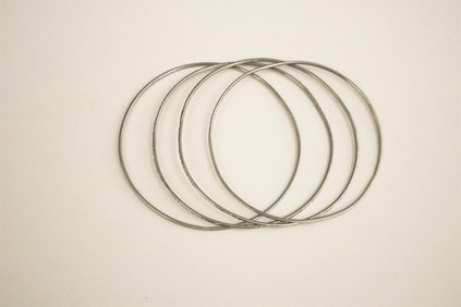 SET OF FOUR 18K WHITE GOLD CIRCULAR, SLIP-ON BANGLE BRACELETS.