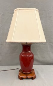 CHINESE SANG-DE-BOEUF GLAZED PORCELAIN VASE MOUNTED ON HAND CARVED TEAKWOOD BASE.