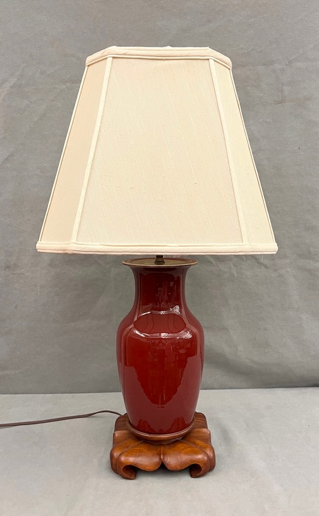 CHINESE SANG-DE-BOEUF GLAZED PORCELAIN VASE MOUNTED ON HAND CARVED TEAKWOOD BASE.: CHINESE SANG-DE-BOEUF GLAZED PORCELAIN VASE MOUNTED ON HAND CARVED TEAKWOOD BASE.