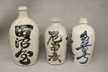GROUP THREE JAPANESE CERAMIC SAKE BOTTLES WITH PAINTED CHARACTER MOTIFS, - Tallest, H: 13 1/2 in.