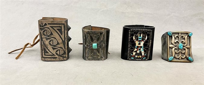 FOUR ASSORTED TRADITIONAL SOUTHWESTERN NATIVE AMERICAN SILVER AND OTHER LEATHER BRACELETS.