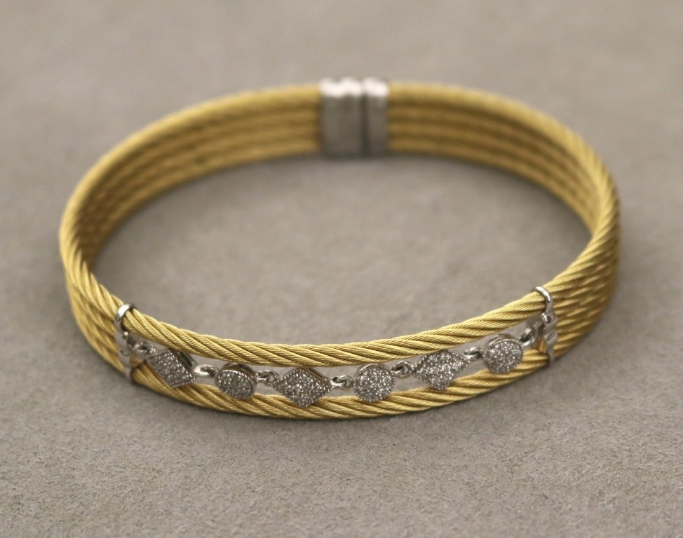 SIGNED CHARRIOL 18K WHITE GOLD, GILT-STEEL AND DIAMOND FLEXIBLE OVAL CABLE DESIGN CUFF BRACELET. -: SIGNED CHARRIOL 18K WHITE GOLD, GILT-STEEL AND DIAMOND FLEXIBLE OVAL CABLE DESIGN CUFF BRACELET. Four matched gold-color cable chains center openwork top section centering three diamond shape and thr