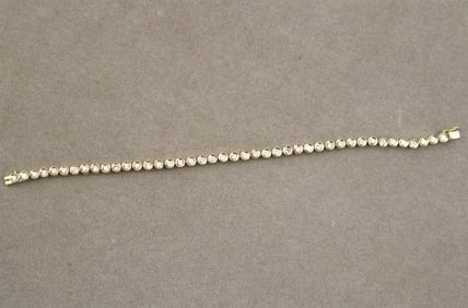 14K YELLOW GOLD AND DIAMOND TENNIS BRACELET. - L: 7 3/8 in.  Gross wt.: 10 dwt.