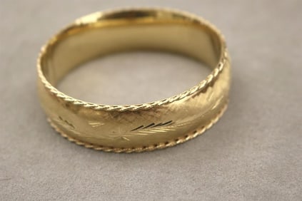 14K TEXTURED YELLOW GOLD HINGED OVAL BANGLE BRACELET. - W: 3/4 in.  Wt.: 18 dwt.