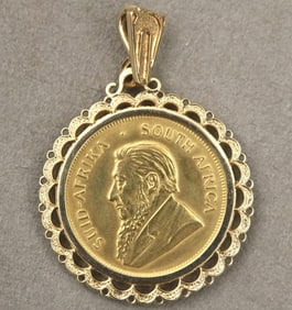 14K YELLOW GOLD FRAMED SOUTH AFRICAN KRUGERRAND PENDANT. - D: 1 1/2 in.