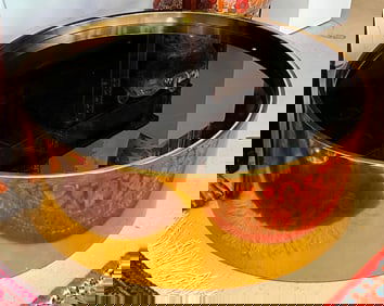 JONATHAN ADLER BRASS-FRAMED DRUM-FORM "ALPHAVILLE" COCKTAIL TABLE WITH BLACK GLASS TOP. - H: 13 in.