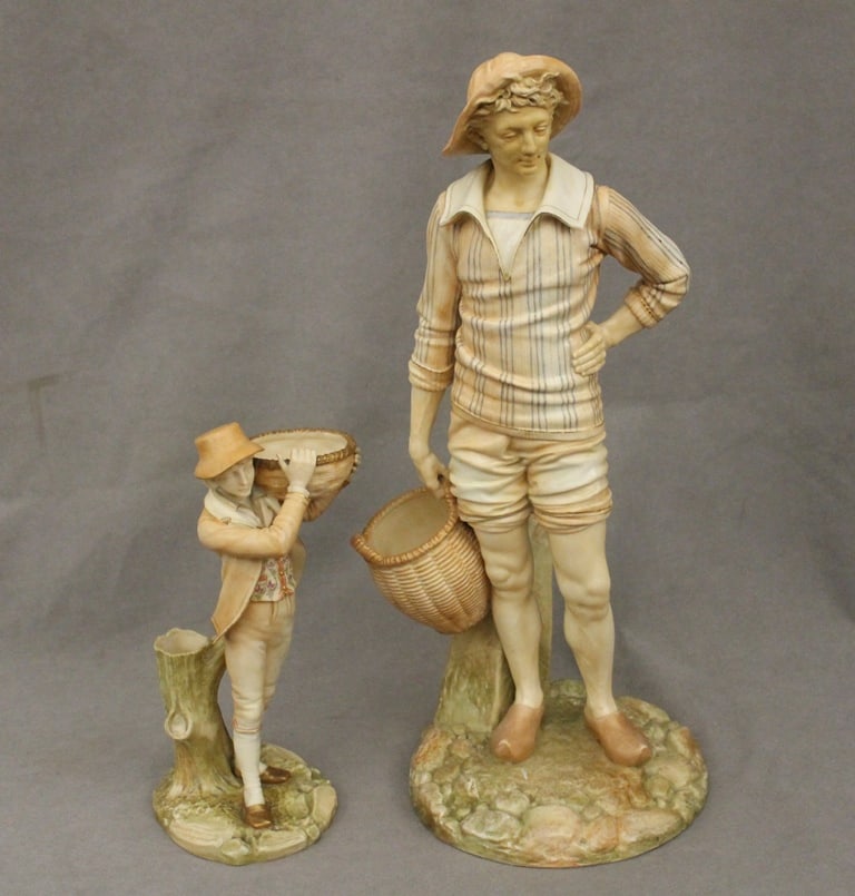 TWO ROYAL WORCESTER POLYCHROMED BISQUE PORCELAIN FIGURES, 19th century. - Taller, H: 17 1/4 in.: TWO ROYAL WORCESTER POLYCHROMED BISQUE PORCELAIN FIGURES, 19th century. Each modeled as male youth standing with basket. - Taller, H: 17 1/4 in.