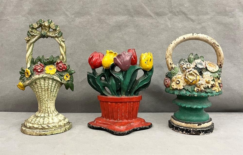THREE 19TH CENTURY MULTI-COLOR PAINTED IRON DOORSTOPS CAST AS FLOWERING BASKETS,: THREE 19TH CENTURY MULTI-COLOR PAINTED IRON DOORSTOPS CAST AS FLOWERING BASKETS.