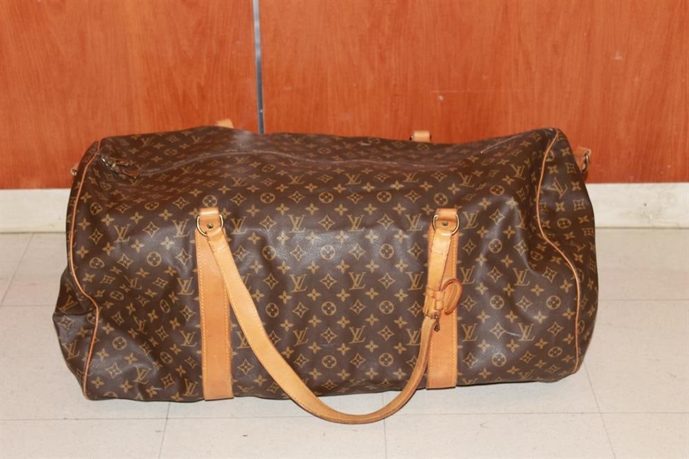 LOUIS VUITTON MONOGRAM CANVAS SAC POLOCHON TRAVEL OR DUFFLE BAG. - L: app 26 in. D: app. 15 in.: LOUIS VUITTON MONOGRAM CANVAS SAC POLOCHON TRAVEL OR DUFFLE BAG. Gold-plated hardware. Removable shoulder strap; zippered interior pocket; with LV stamped padlock and two keys; leather luggage tag an