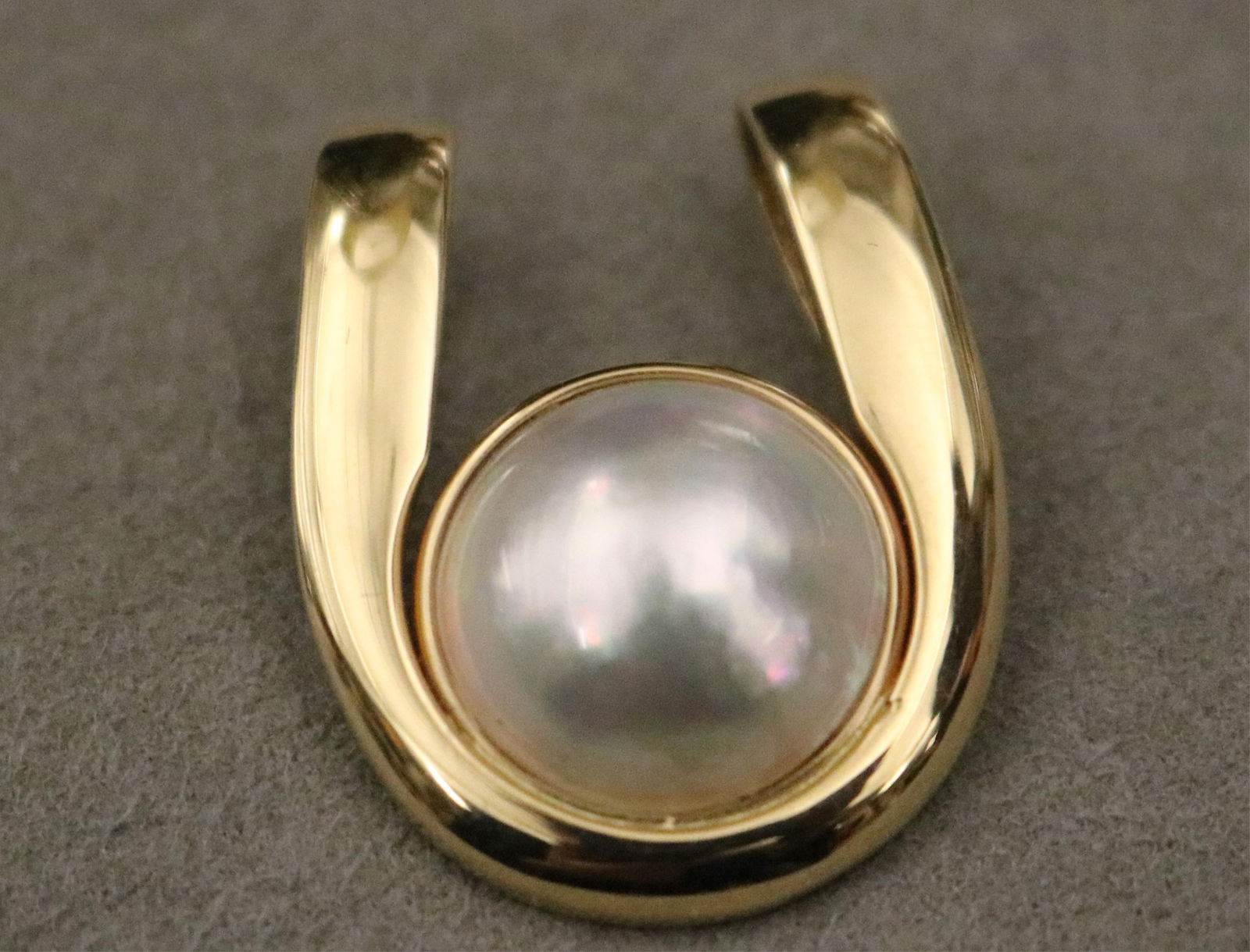14K BRIGHT-POLISHED YELLOW GOLD AND MABE PEARL PENDANT/NECKLACE ENHANCER L: 1 1/8 in. Gross wt. 5: 14K BRIGHT-POLISHED YELLOW GOLD AND MABE PEARL PENDANT/NECKLACE ENHANCER14.43 mabe pearl centered in U-shape setting.L: 1 1/8 in. Gross wt. 5 dwt.
