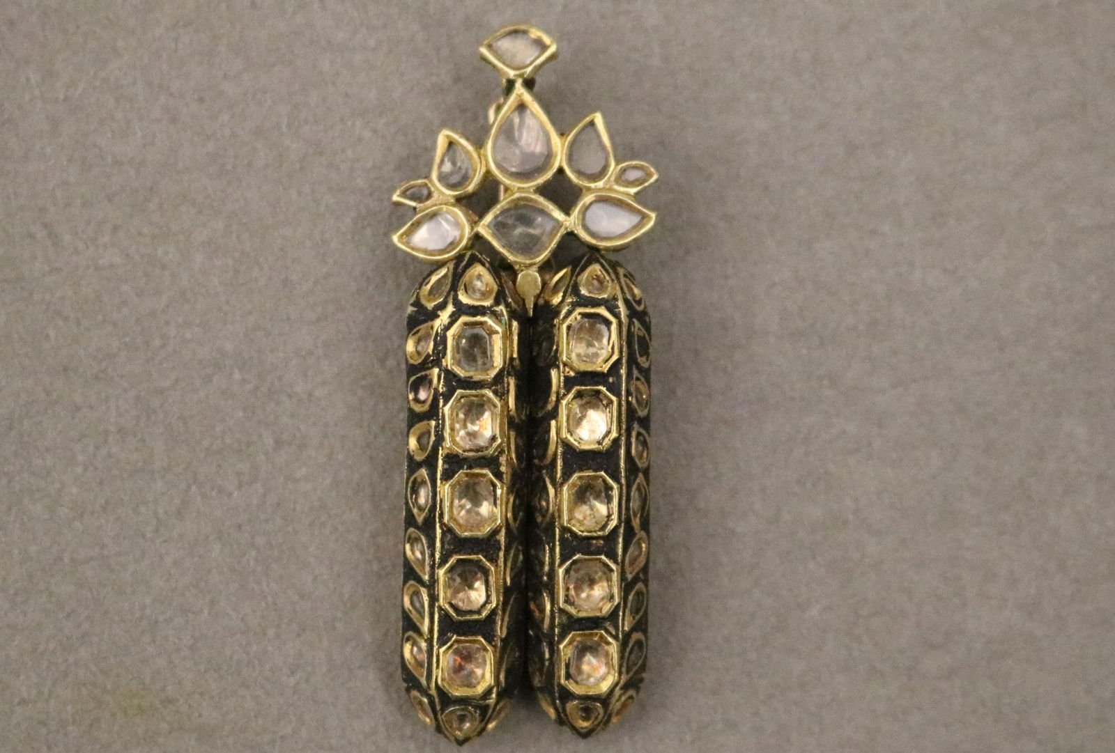 INDIAN YELLOW GOLD, RED AND GREEN ENAMEL AND WHITE SAPPHIRE PENDANT/NECKLACE ENHANCER L: 2 3/8 in.: INDIAN YELLOW GOLD, RED AND GREEN ENAMEL AND WHITE SAPPHIRE PENDANT/NECKLACE ENHANCERPair oblong ornaments with enamel floral decoration and numerous cushion and and leaf shape sapphires, crowned by c