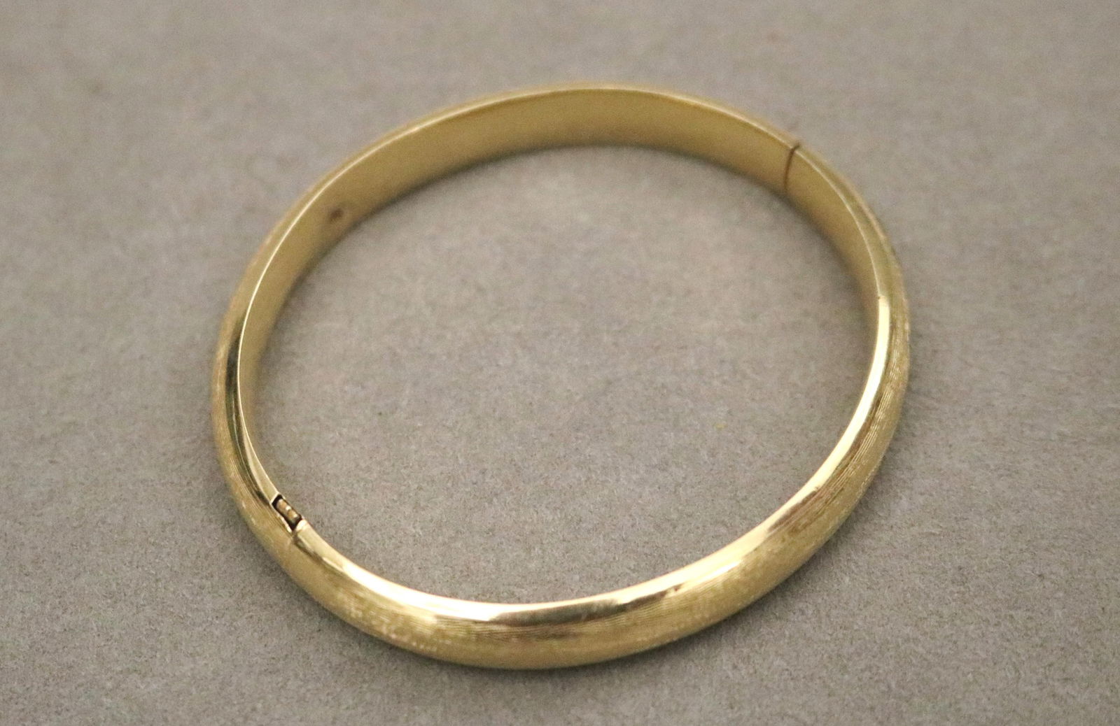 14K (STAMPED) FLORENTINE-TEXTURED YELLOW GOLD HINGED OVAL BANGLE BRACELET. (1 of 5)