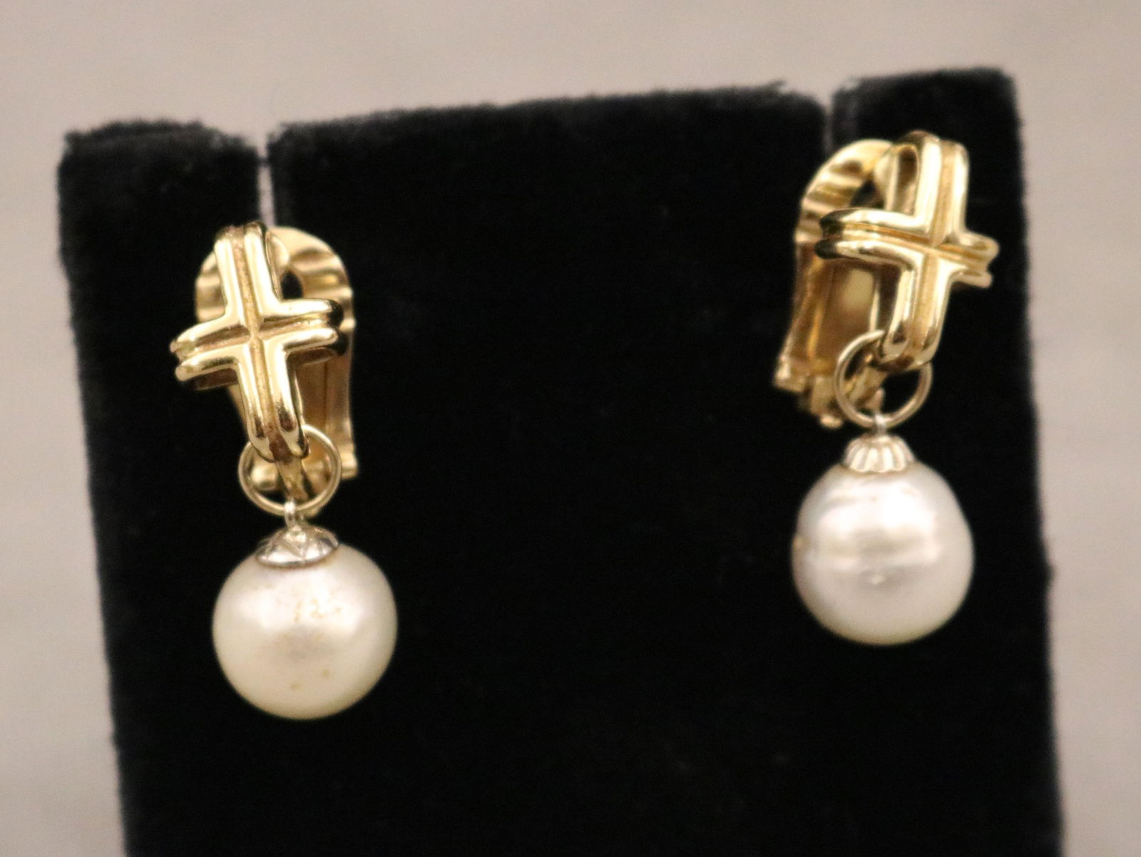 PAIR GOLD AND BAROQUE PEARL DANGLE EARRINGS: PAIR GOLD AND BAROQUE PEARL DANGLE EARRINGSRibbed cross form anchor suspends freely-swinging 11mm baroque pearl; clip-post backs.L 1 1/8 in. Gross wt. 8 dwt