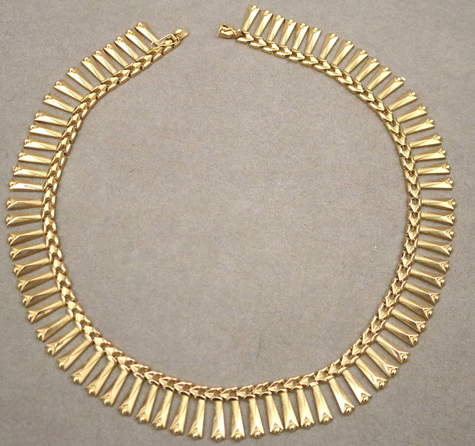 18K (STAMPED) TEXTURED AND SMOOTH-POLISHED FRINGE STYLE CHOKER.: 18K (STAMPED) TEXTURED AND SMOOTH-POLISHED FRINGE STYLE CHOKER.Tongue-and-groove clasp. L: 17”. W: 11/16”. Wt.: 1 oz. 10 dwt.