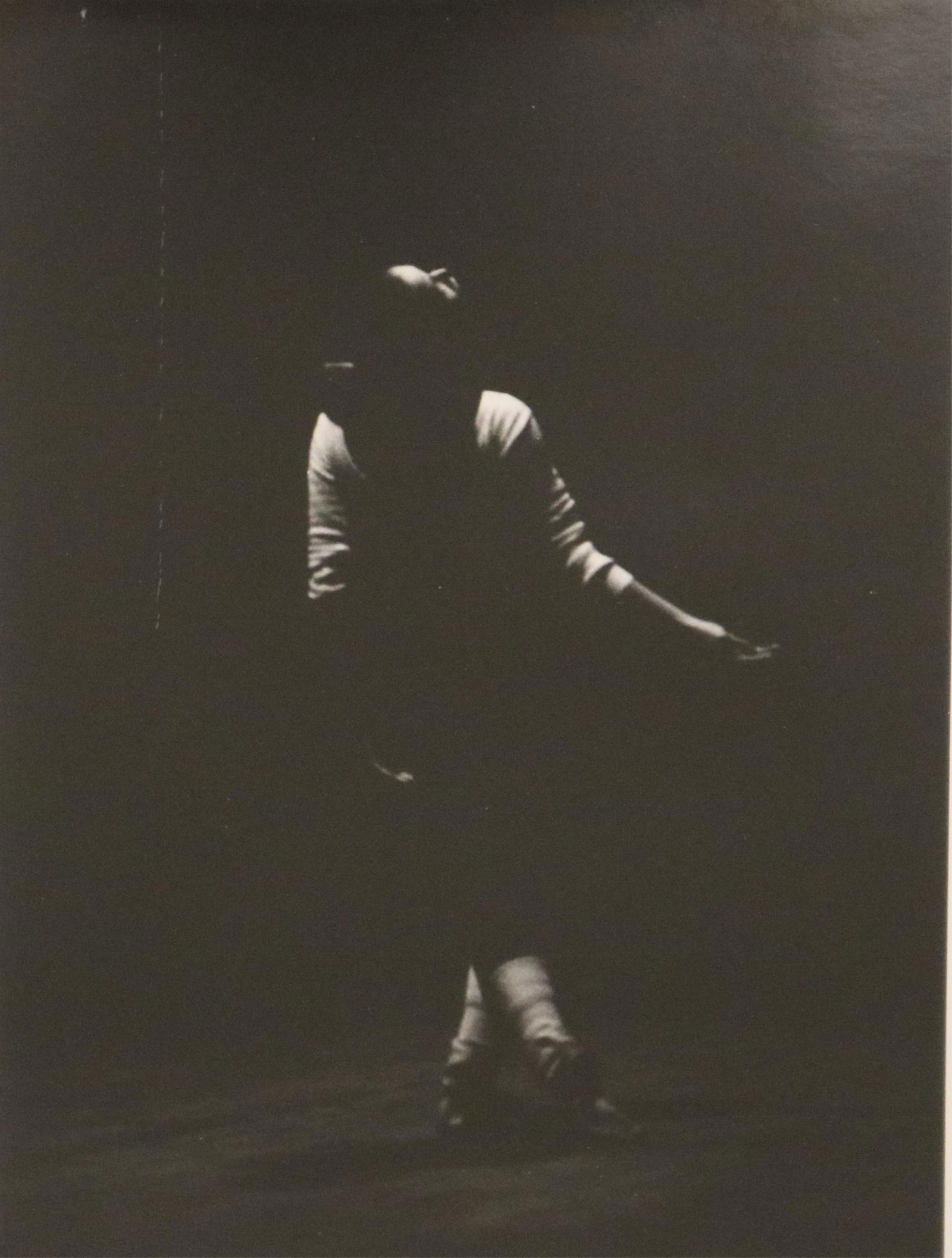Contemporary American Artist , 20th century, Solitary Dancer against a Dark, Minimalist Background,: CONTEMPORARY AMERICAN ARTIST20th centurySolitary Dancer against a Dark, Minimalist BackgroundphotographThis black-and-white photograph features a solitary figure, likely a dancer, set against a dark a