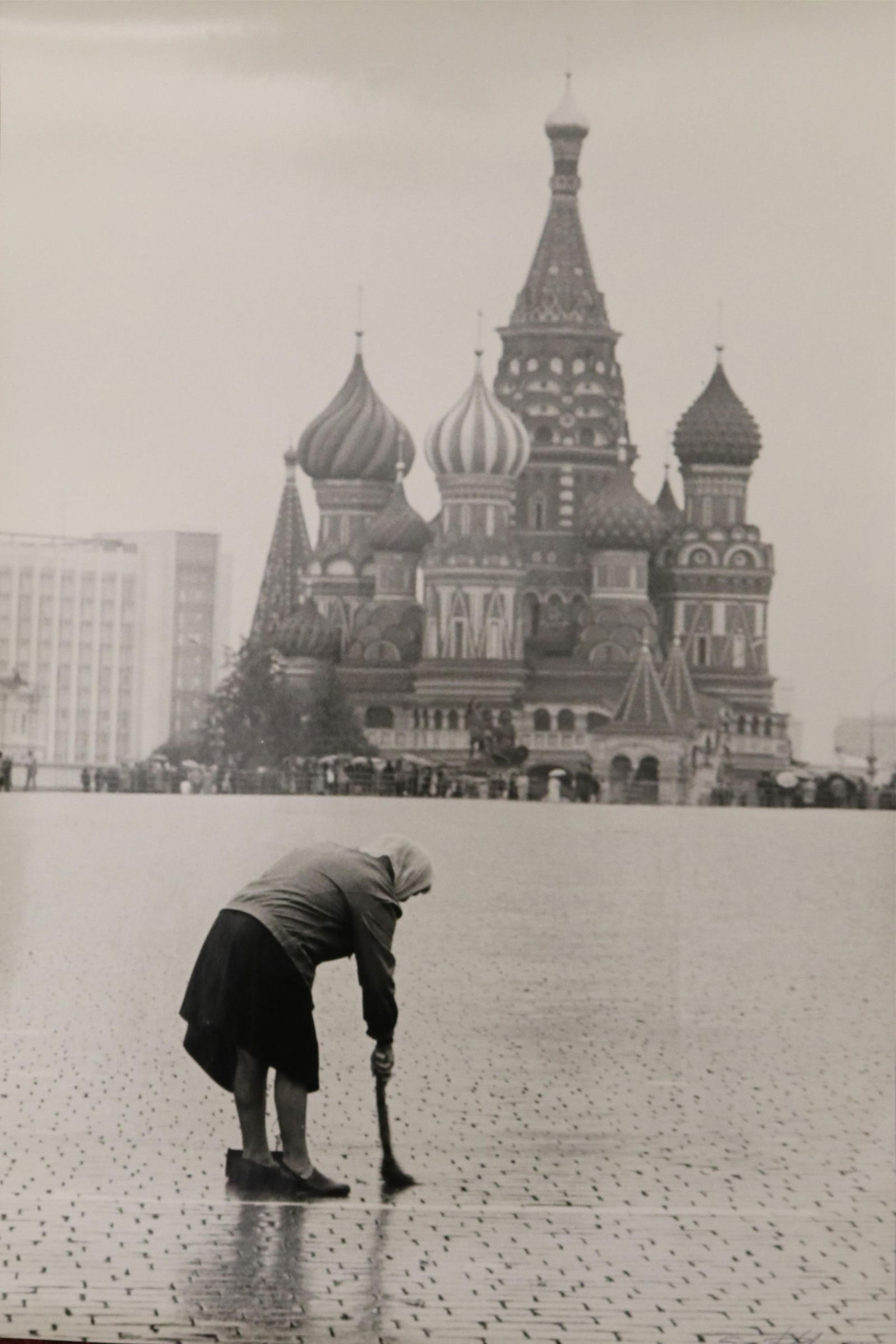 Sergei Petrov, Russian Born 1953, Lady on the Red Square, 1981, 22.5 x 15 inches: SERGEI PETROVRussian, Born 1953Lady on the Red Square, 1981Black and white photograph. Ink signed and dated "81" lower right. Unframed. Verso titled, dated and signed. Photograph captures a an elderly