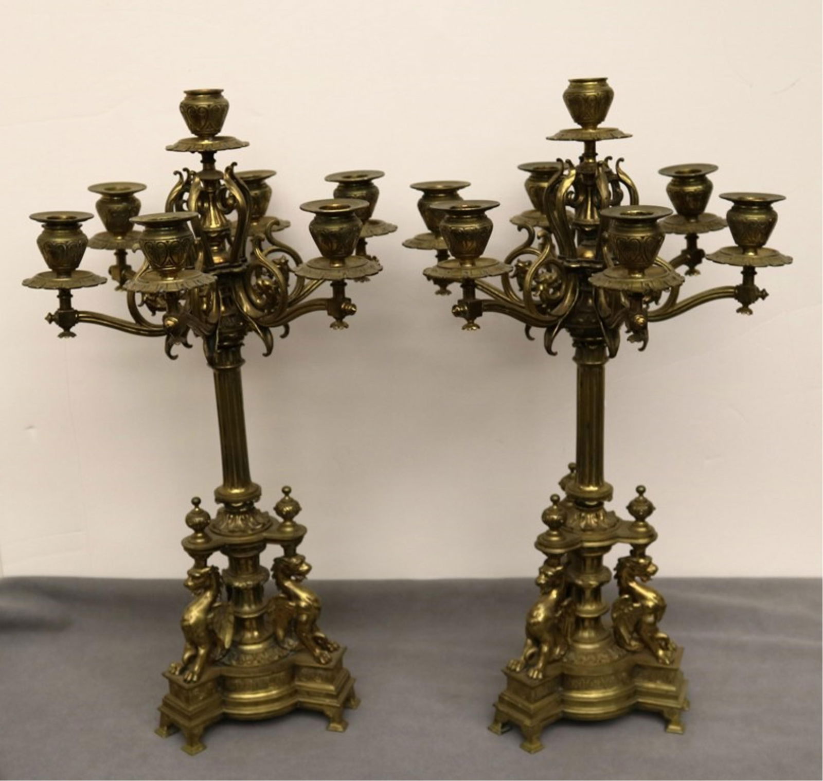 PAIR RENAISSANCE REVIVAL BRASS SEVEN-LIGHT CANDELABRA. 19th century - H: 24 in..: PAIR RENAISSANCE REVIVAL BRASS SEVEN-LIGHT CANDELABRA. 19th century Column supports each with three cast griffin at base, issue six scrolling arms terminating in nozzles and centering seventh nozzle w