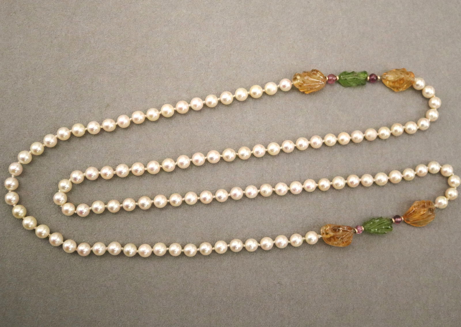MATCHED CULTURED PEARL NECKLACE WITH CARVED CITRINE, PERIDOT AND PINK TOURMALINE STATIONS - L: 42: MATCHED CULTURED PEARL NECKLACE WITH CARVED CITRINE, PERIDOT AND PINK TOURMALINE STATIONS 8mm pearls with two sections of leaf-carved citrons and peridots and four tourmaline spacer beads L: 42 in.