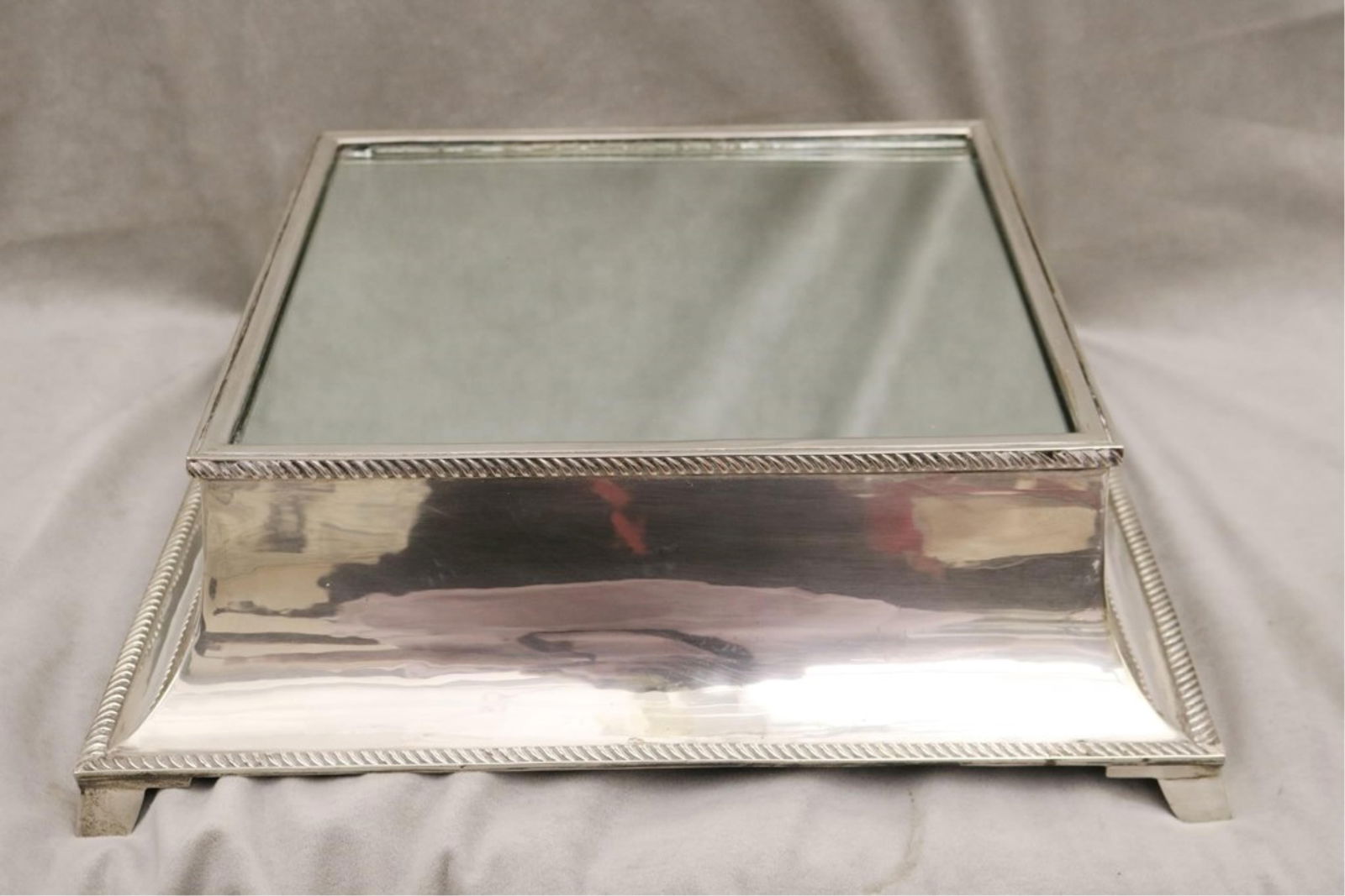 NEOCLASSICAL STYLE HEAVY SILVER-PLATED SQUARE MIRRORED PLATEAU - H: 5 ½". 16 3/8" square..: NEOCLASSICAL STYLE HEAVY SILVER-PLATED SQUARE MIRRORED PLATEAU Cove-molded sides; gadrooned upper and lower borders; flaring squared feet. H: 5 ½". 16 3/8" square.