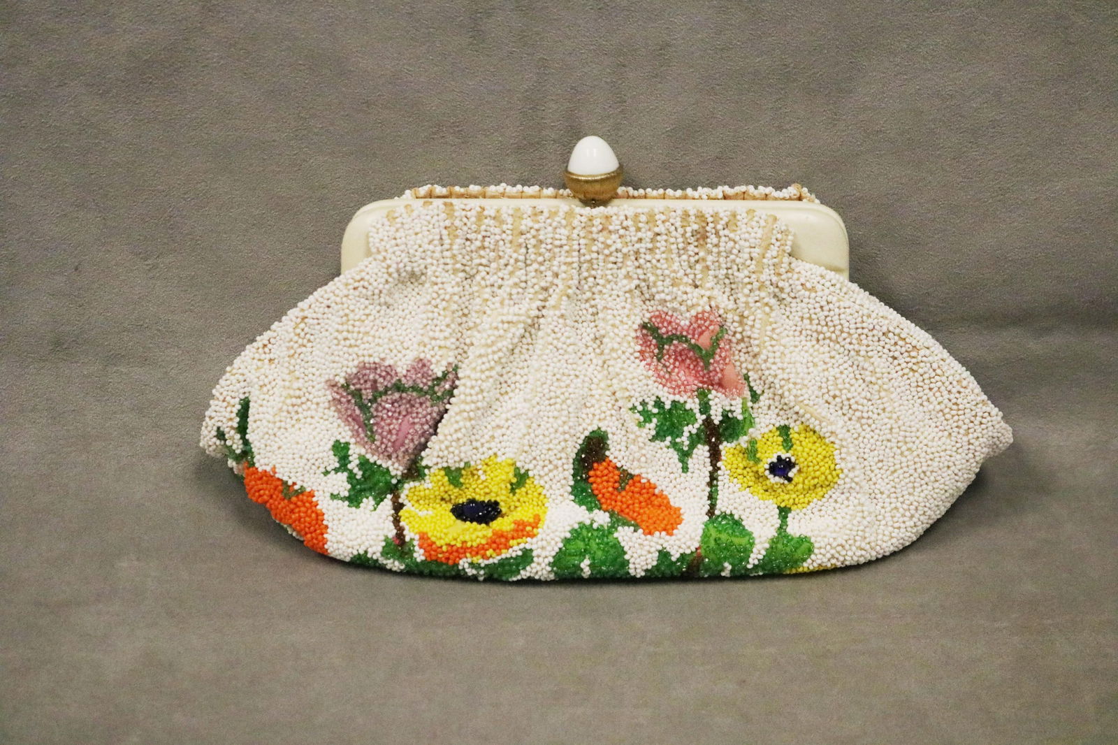 NETTIE ROSENSTEIN BEADED FLORAL CLUTCH OR EVENING BAG - .: NETTIE ROSENSTEIN BEADED FLORAL CLUTCH OR EVENING BAG Beaded configuration of pink, yellow, red and orange blossoms on white ground; green fabric interior marked "Nettie Rosenstein"
