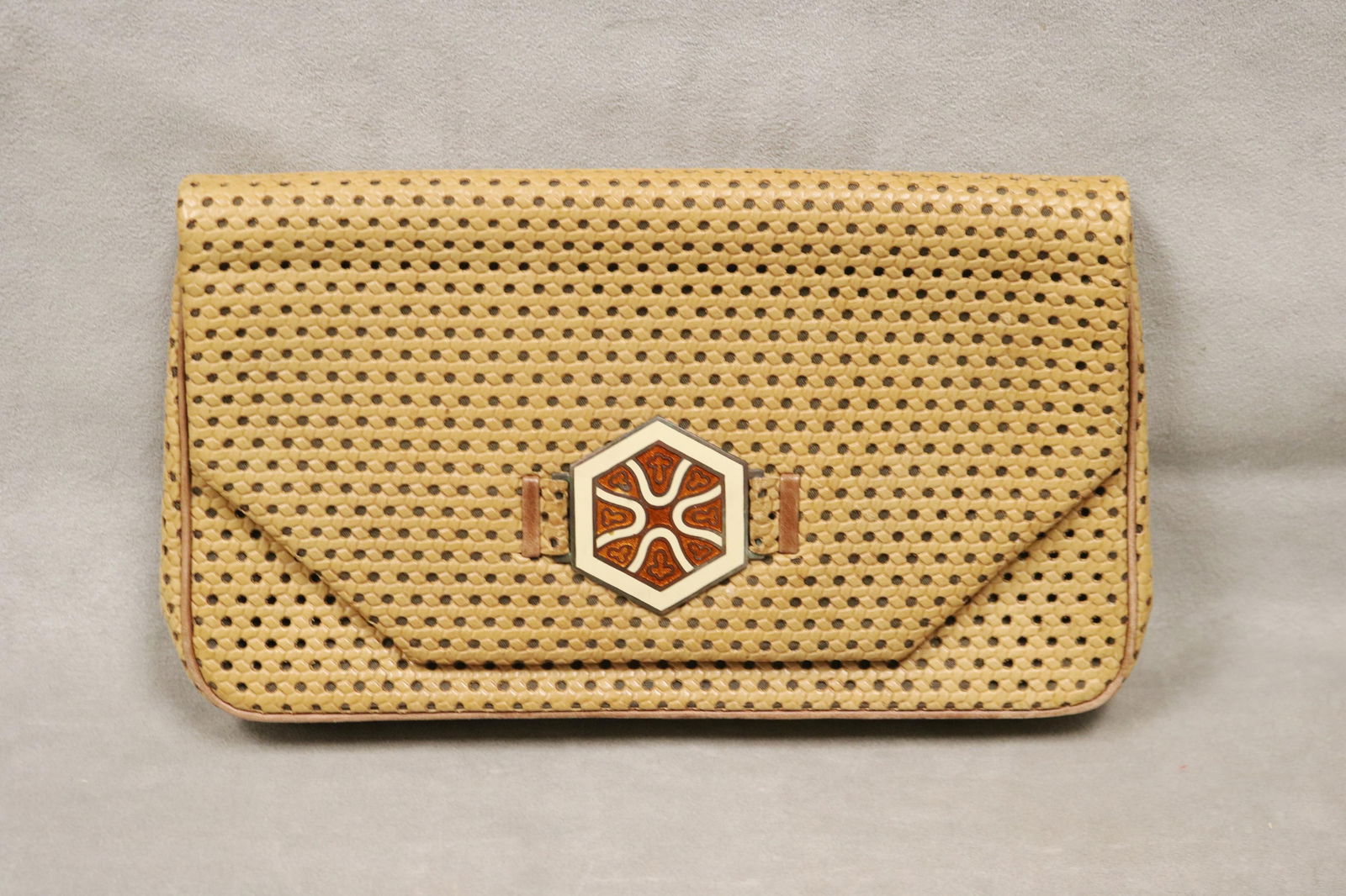 JACOMO (PARIS) TAN LEATHER ENVELOPE-FORM CLUTCH - .: JACOMO (PARIS) TAN LEATHER ENVELOPE-FORM CLUTCH All-over openwork and embossed decoration; one interior pocket with zipper opening and two other pockets. Hexagonal medallion with burnt orange