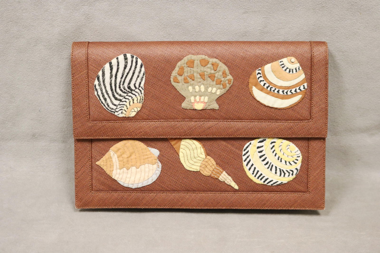 RENAUD PELLEGRINO BROWN LINEN FOLD-OVER CLUTCH WITH APPLIQUED SEASHELL DECORATION - .: RENAUD PELLEGRINO BROWN LINEN FOLD-OVER CLUTCH WITH APPLIQUED SEASHELL DECORATION Various cloth-appliqued seashells with embroidered accents adorn front and revers