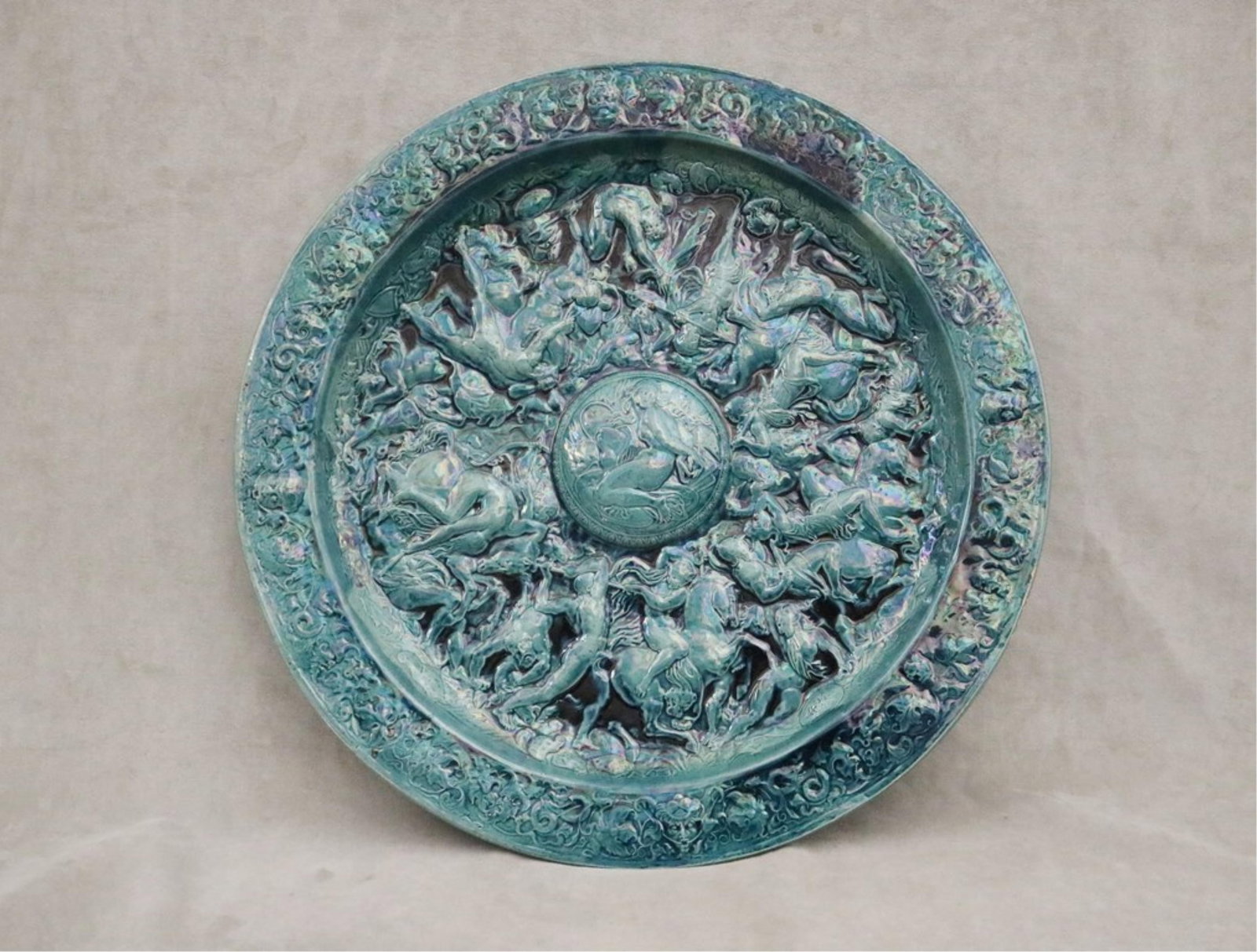 ITALIAN IRIDESCENT TEAL GLAZED RELIEF CHARGER - D; 25 1/4 in..: ITALIAN IRIDESCENT TEAL GLAZED RELIEF CHARGER Frieze of ancient Roman battle scene D; 25 1/4 in.