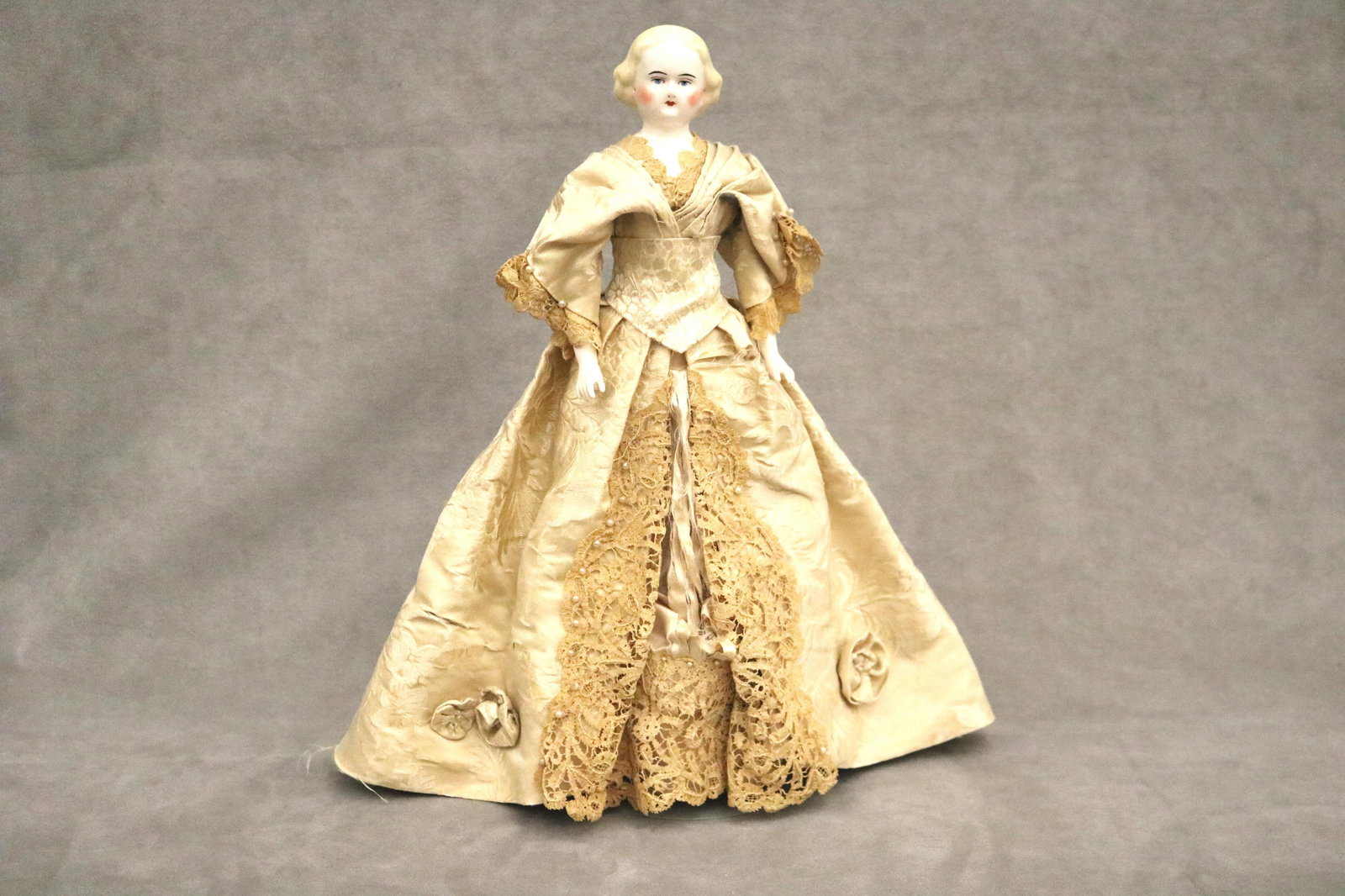 MID-19TH CENTURY PORCELAIN HEAD DOLL WITH PAINTED BLONDE HAIR - Height: 15", overall.: MID-19TH CENTURY PORCELAIN HEAD DOLL WITH PAINTED BLONDE HAIR Lace trimmed vintage clothing. Height: 15", overall