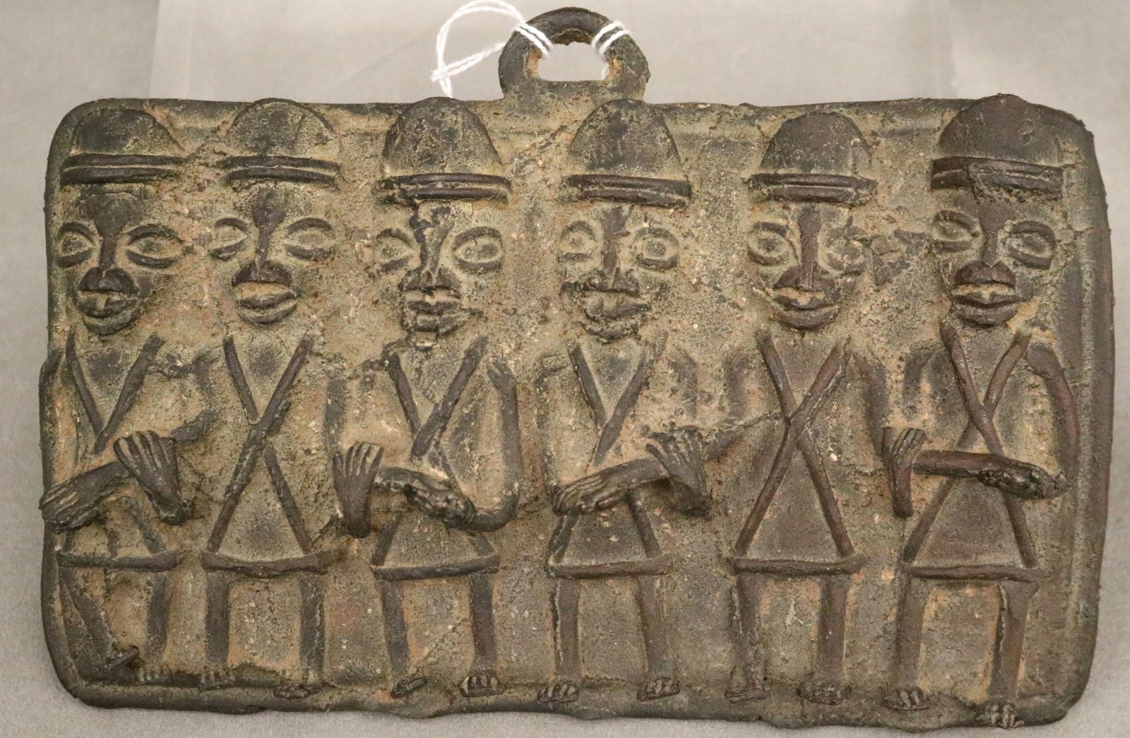 NIGERIAN BENIN-STYLE SAND CAST BRONZE EDO PLAQUE - 5.5 x 8.5 inches.: NIGERIAN BENIN-STYLE SAND CAST BRONZE EDO PLAQUE This Benin-style sand cast bronze plaque is a modern homage to the historic relief sculptures that once adorned the royal palace of the Oba in the King