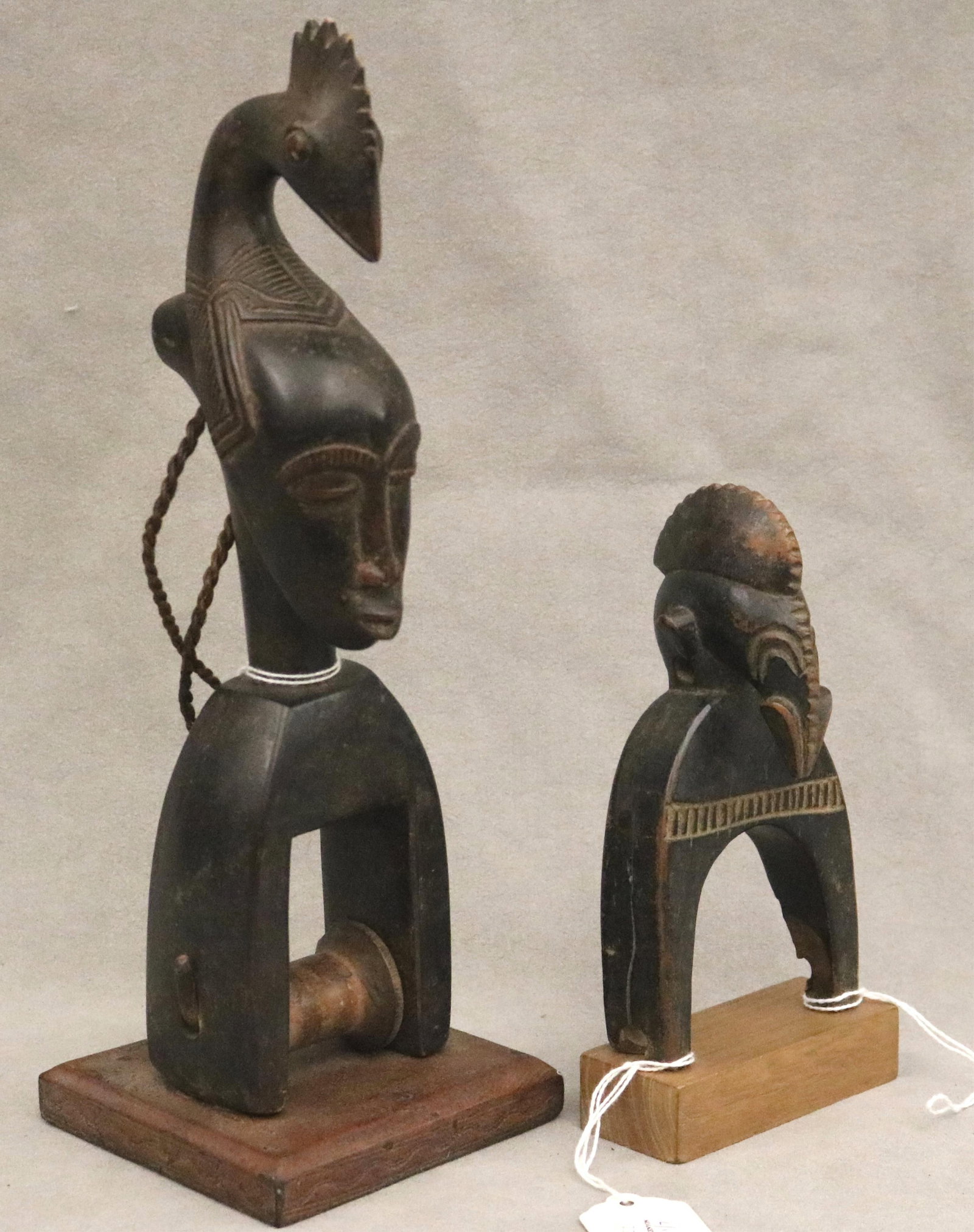 IVORY COAST GURO HEDDLE PULLEYS - height: 11.75 inches (tallest pulley).: IVORY COAST GURO HEDDLE PULLEYS This pair of Guro heddle pulleys from the Ivory Coast illustrates the sophisticated merging of functional weaving technology with refined West African sculptural aesthe