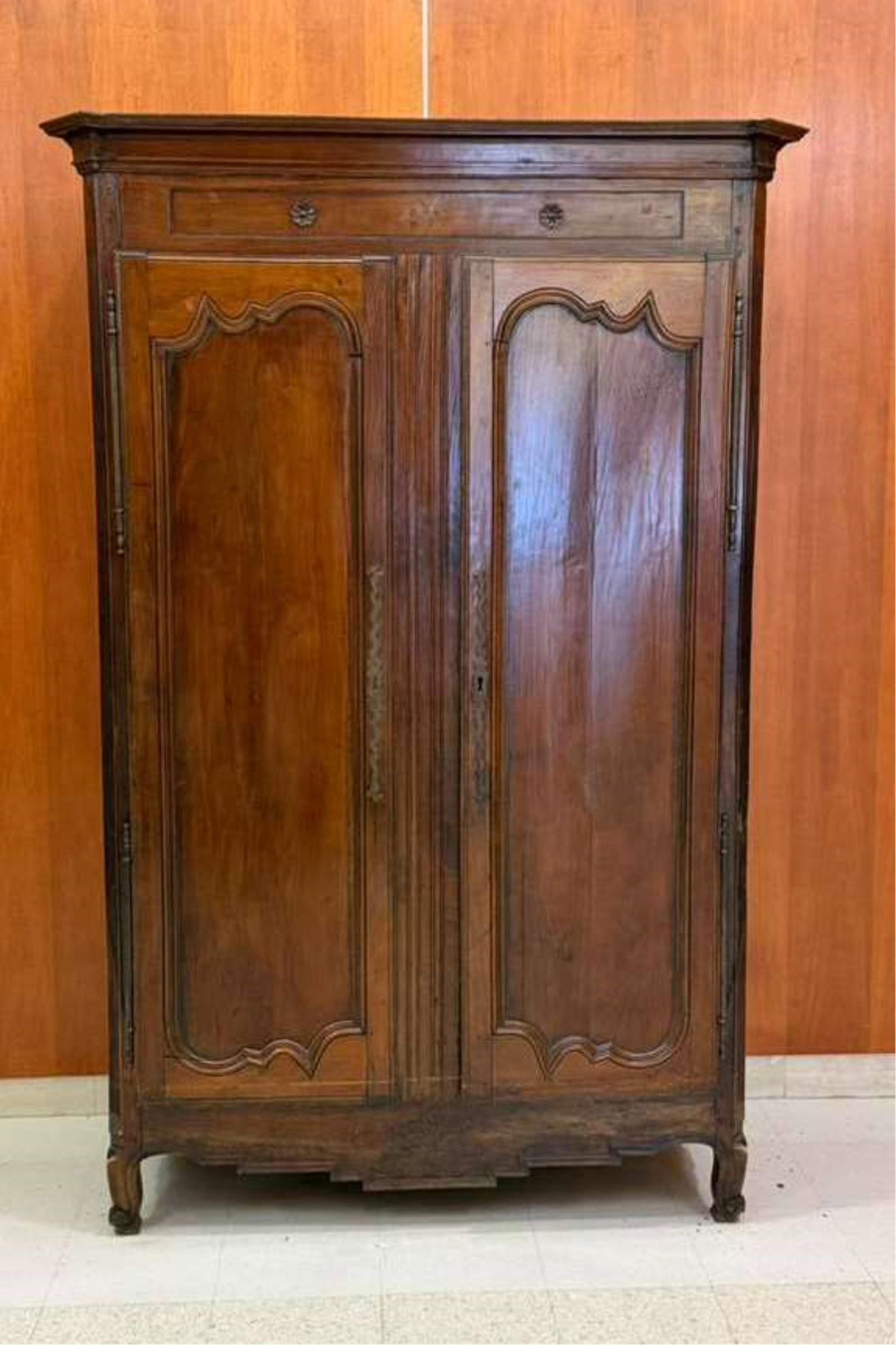 FRENCH PROVINCIAL CHERRYWOOD ARMOIRE 18th century - H: 84 in. W: 54 in. D: 26 in..: FRENCH PROVINCIAL CHERRYWOOD ARMOIRE 18th century Flat, molded pediment over frieze panel with carved flowerhead medallions above pair paneled cabinet doors; reeded, canted corners; scroll feet H: 84