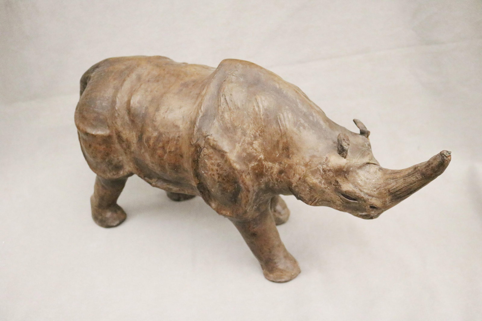 BROWN LEATHER COVERED FIGURE OF STANDING RHINOCEROS - H: 10 1/2 in. L: 21 in..: BROWN LEATHER COVERED FIGURE OF STANDING RHINOCEROS Excellent condition H: 10 1/2 in. L: 21 in.