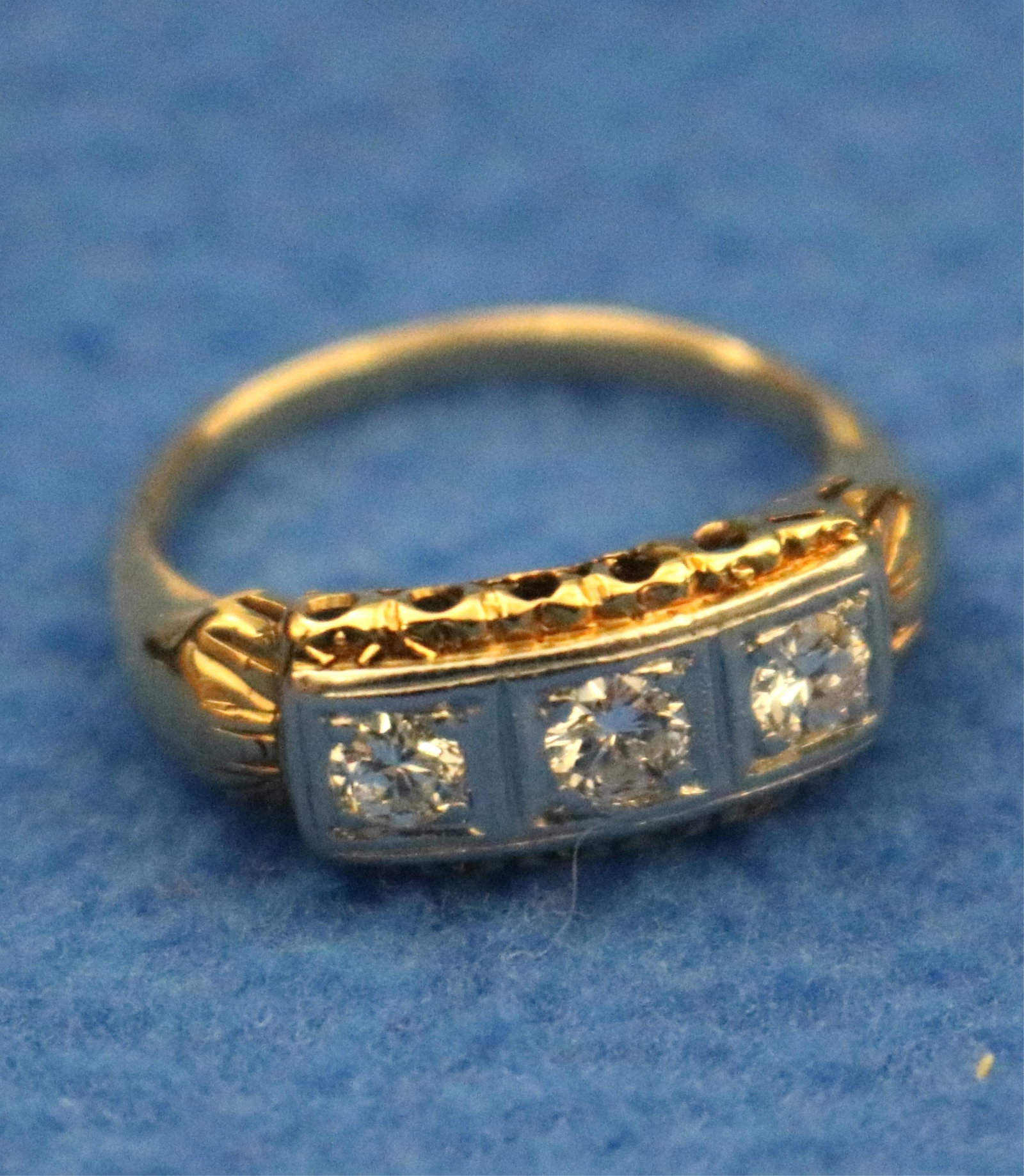 14K YELLOW AND WHITE GOLD AND DIAMOND RING mid 20th century - Ring size: 6 1/4. Gross wt. 2 dwt.: 14K YELLOW AND WHITE GOLD AND DIAMOND RING mid 20th century Horizontally-set row of three matched, transtional brilliant-cut round diamonds each weighing app. .20 ct., each held by corner prongs in in