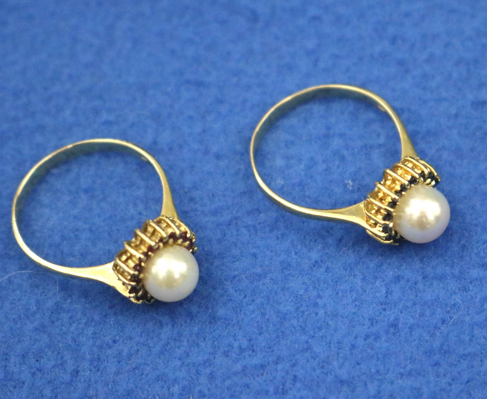 PAIR 14k (585) BRIGHT-POLISHED YELLOW GOLD, CULTURED PEARL AND COLORED GEMSTONE RINGS - Ring size: 8: PAIR 14k (585) BRIGHT-POLISHED YELLOW GOLD, CULTURED PEARL AND COLORED GEMSTONE RINGS One, with pearl surrounded by 16 matched round sapphires; other with matched round rubies. Ring size: 8 1/2. Gross