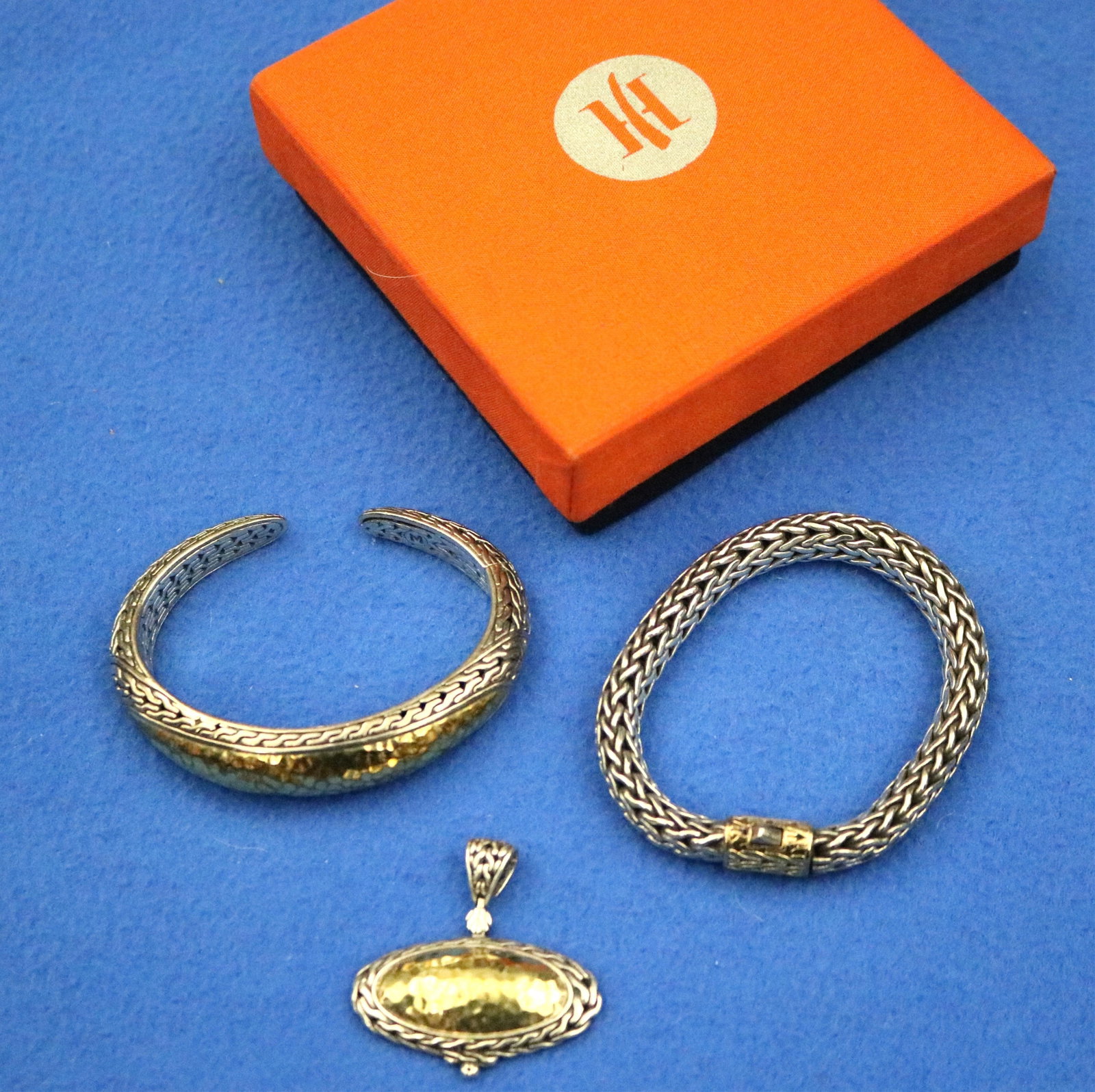 THREE ITEMS SIGNED JOHN HARDY STERLING SILVER AND YELLOW GOLD JEWELRY - Gross wt.: 4 oz.7 dwt..: THREE ITEMS SIGNED JOHN HARDY STERLING SILVER AND YELLOW GOLD JEWELRY Including woven tubular flexible bracelet with 18K gold-mounted oval cylindrical textured clasp, L:8"; open-end, tapering oval ban